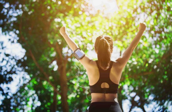 Young woman engaged in sports while listening to music. Take a resting and drinking water.