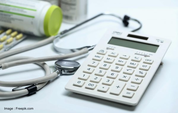 calculator, stethoscope and medicine bottles on white background